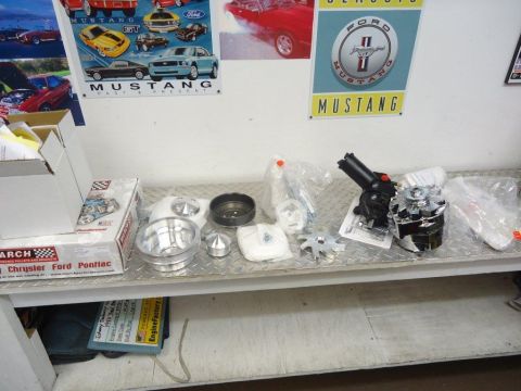 1982 Ford Bronco - Various engine components are laid out on a workbench, with posters on the wall behind.