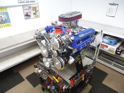 1982 Ford Bronco - A custom Ford V8 engine with chrome accents and blue racing wires sits on a tool cart.