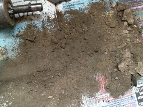 1987 Ford Bronco - Dirt and a metal part are on top of newspaper, with a Supermotors.net logo in the corner.