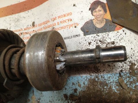 1987 Ford Bronco - A close-up view of a starter motor part, possibly for an older vehicle, resting on a surface with dirt and a newspaper clipping.