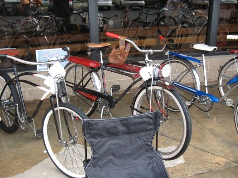 Several vintage bicycles lined up, one with a red seat and chrome fenders