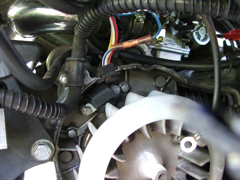 Engine close-up showing carburetor, wiring, and fan shroud