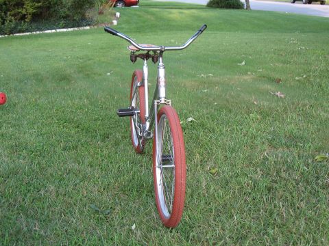 bicycle with red tires and chrome handlebars on grass