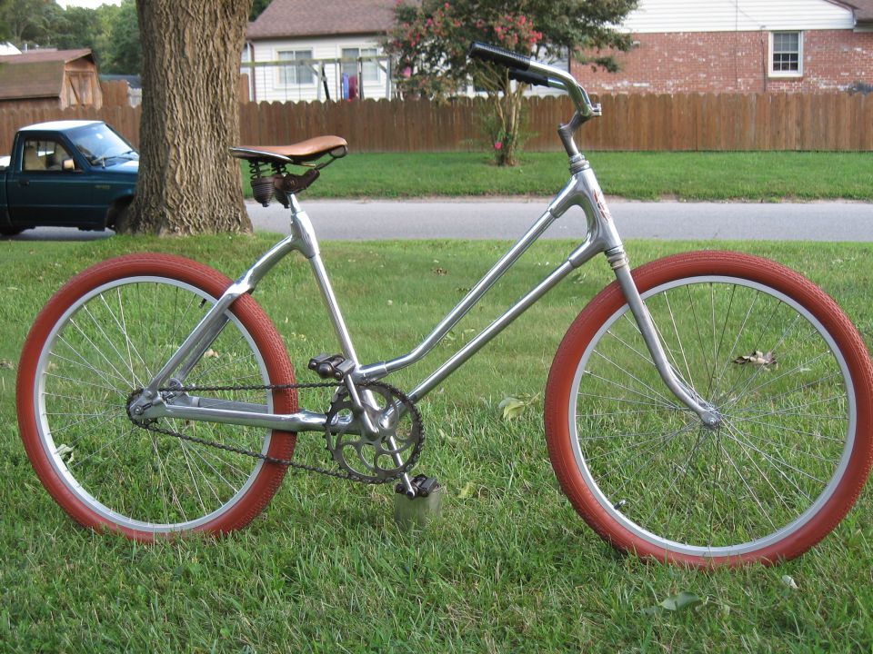 Silver cruiser bicycle with red tires and brown leather seat