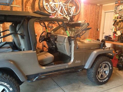 2005 Jeep Wrangler - Side view of a 2005 Jeep Wrangler with its doors off, parked inside a garage.