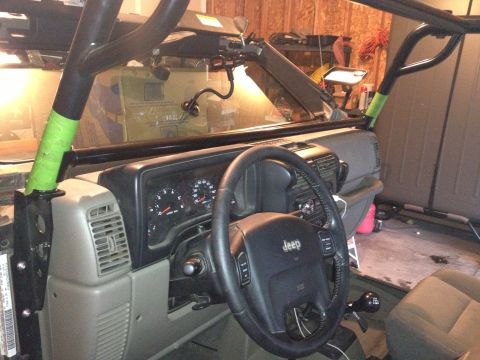 2005 Jeep Wrangler - The interior of a Jeep Wrangler is shown, a roll cage and dashboard instrumentation.