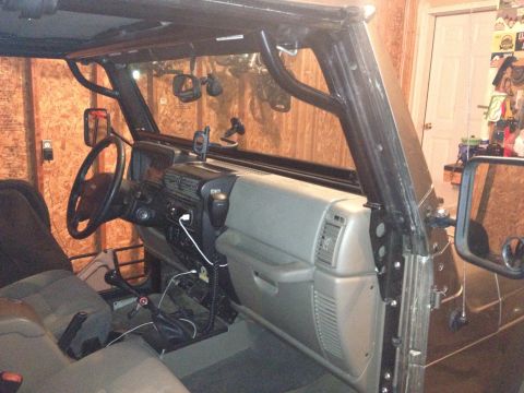 2005 Jeep Wrangler - Interior view of a Jeep Wrangler, highlighting the dashboard and an aftermarket roll cage.