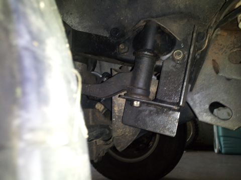 2003 Nissan Frontier - Close-up view of the underbody suspension components and a tire, showing mechanical parts of the vehicle.
