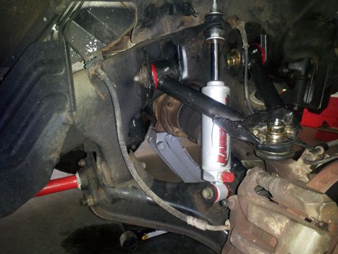 2003 Nissan Frontier - The front suspension system shows upgraded components, including a shock absorber and sway bar.