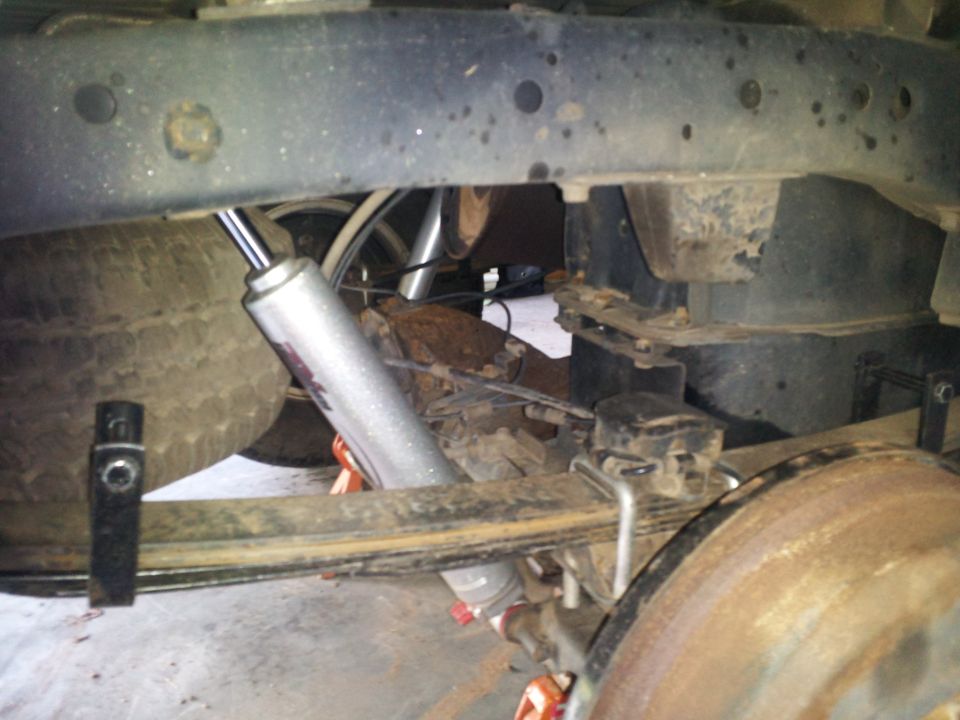 Rear leaf springs, shock absorber, and brake drum on a vehicle