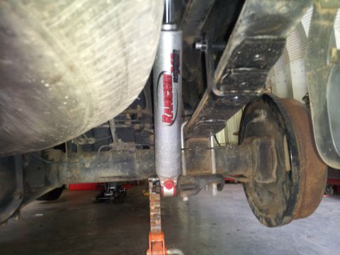 2003 Nissan Frontier - Underside view of a vehicle's rear suspension, showing a Rancho shock absorber and leaf springs.