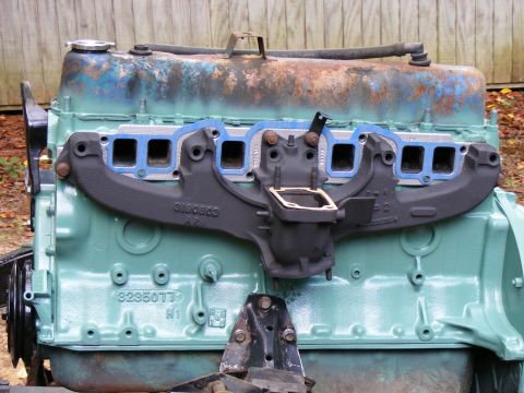Engine block painted teal with black intake manifold and blue gaskets. Part number S190803 visible