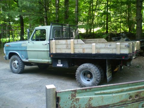 1979 Ford Bronco - This flatbed truck, likely a 1979 model based on its body style, features a two-tone paint scheme and wooden bed sides.