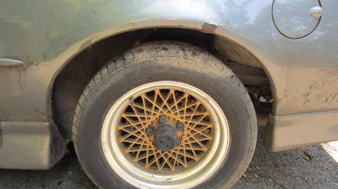 1987 Pontiac Firebird - Close-up of the rear wheel well and fender of a 1987 Pontiac Firebird, showing some rust and dirt.