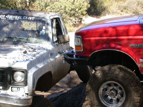 1996 Ford Bronco - Two off-road vehicles are stuck in the mud, with a 1996 Ford Bronco visible on the right.