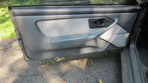 1987 Pontiac Firebird - Interior door panel of a car, showing the armrest and handle mechanism.