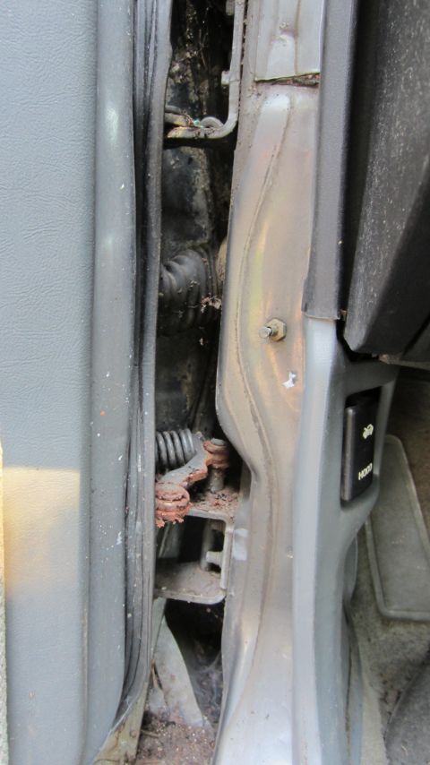 1987 Pontiac Firebird - Close-up view of the door jamb and hinge assembly on a vehicle.