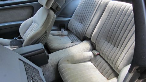 1987 Pontiac Firebird - The interior of a 1987 Pontiac Firebird, grey fabric seats and a center console.