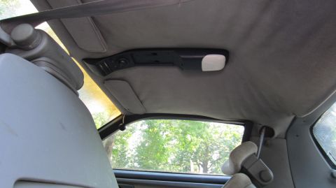 1987 Pontiac Firebird - Interior view of car ceiling showing sun visors and overhead console.