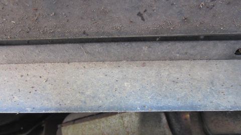 1987 Pontiac Firebird - Close-up view of the undercarriage of a vehicle, showing metal components and dirt accumulation.