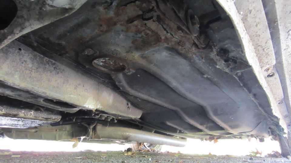 underside of a car showing rust and damage