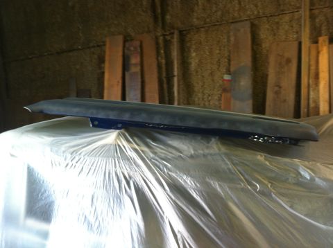 1982 Ford Bronco - A dark dashboard component, possibly for a classic vehicle, is covered in plastic sheeting in a workshop.