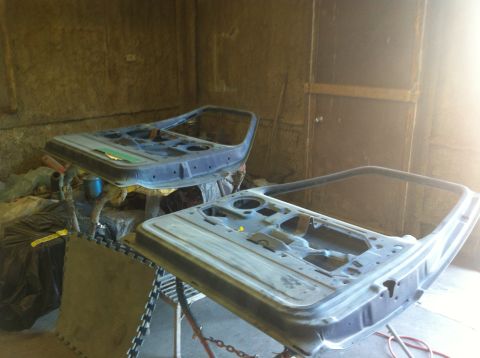 1982 Ford Bronco - Two car doors are disassembled and prepped for work in a garage setting.