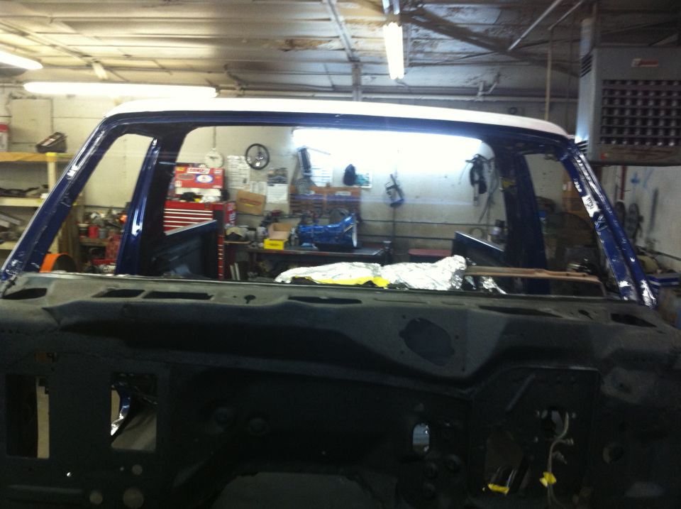 1978 Ford Bronco body shell, blue and white, undergoing restoration in a workshop
