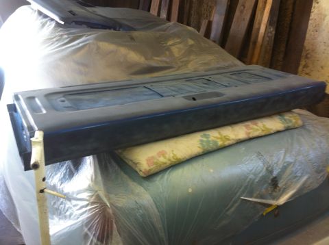 1982 Ford Bronco - A blue tailgate, likely from a 1982 Ford Bronco, is covered and resting on a patterned cloth.
