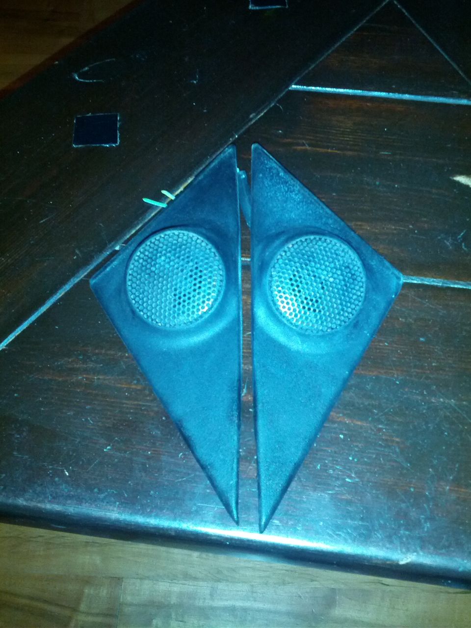 Two triangular speaker pods with grilles