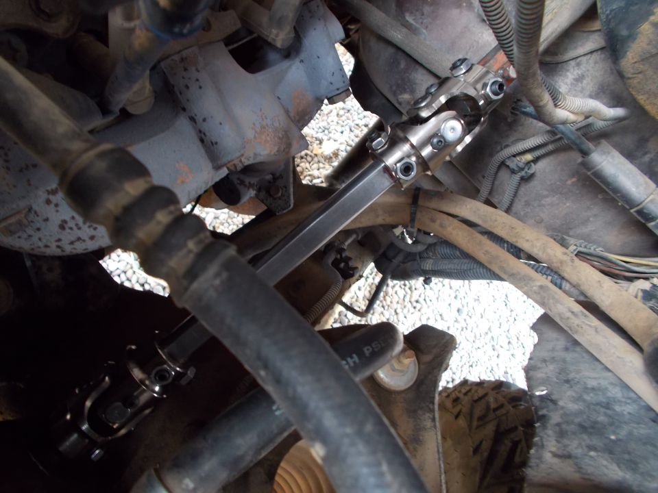Close-up of a steering shaft U-joint and shaft assembly, likely from a truck or SUV