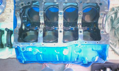 1996 Ford Bronco - Engine block with connecting rods visible. Blue fluid is present in the cylinders.
