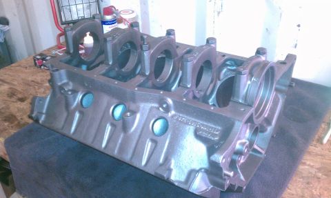 1996 Ford Bronco - Engine block with main bearing caps installed, sitting on a workbench. Text is visible on the side.