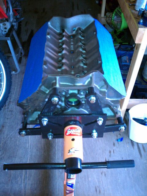 1996 Ford Bronco - Engine block on an engine stand, with blue tape covering parts of it.