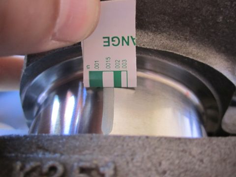 1996 Ford Bronco - Using a feeler gauge to check clearance on an engine part.