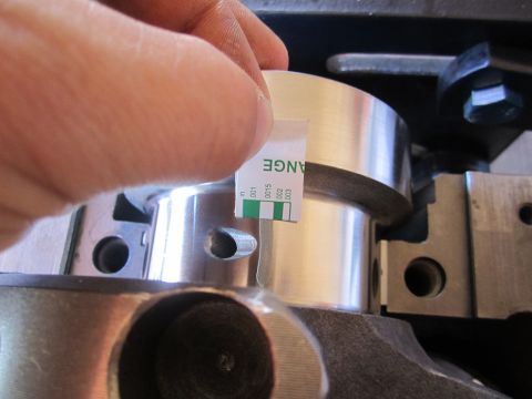 1996 Ford Bronco - A feeler gauge is used to measure the clearance on a metal engine part.