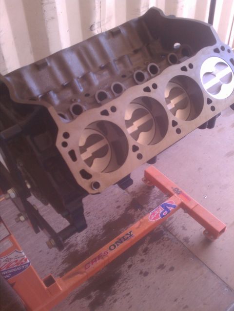 1996 Ford Bronco - Engine block with pistons visible, supported by an orange engine stand.