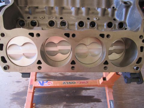 1996 Ford Bronco - Close-up view of an engine block with pistons installed, resting on a stand.