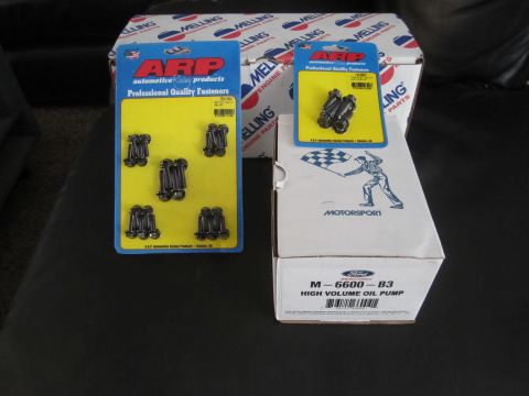 1996 Ford Bronco - Automotive parts including ARP fasteners and a Ford oil pump are displayed on a dark surface.