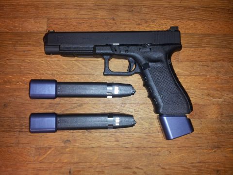 1996 Ford Bronco - A black handgun is displayed with two additional magazines and an extended magazine base plate.