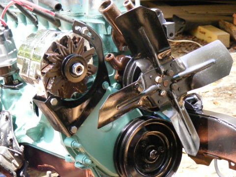 Close-up of an engine assembly with an alternator and fan