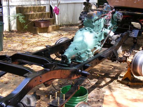Vehicle frame with teal engine and transmission, viewed from the side