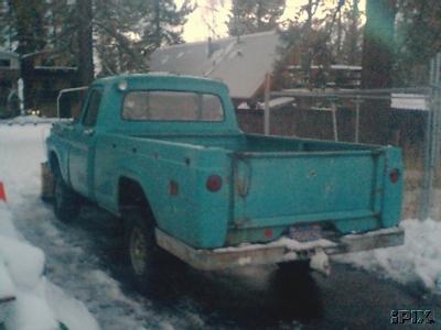 1963 Ford F-250 - A turquoise pickup truck is parked on a snowy driveway with trees and a house in the background.