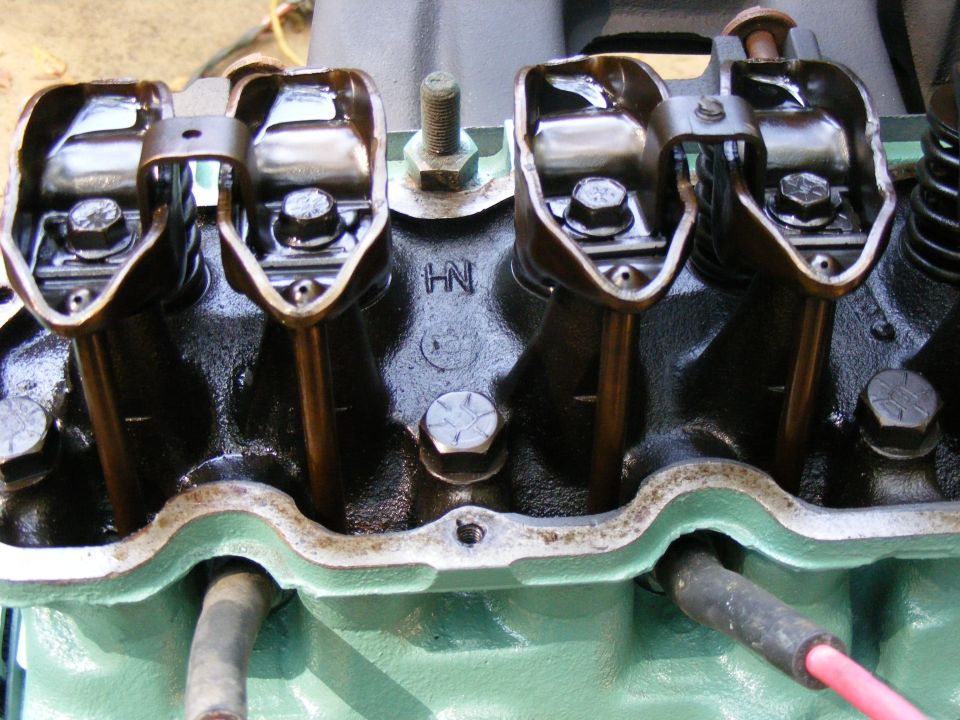 Engine valve train with rocker arms and pushrods visible. 'HN' cast into block
