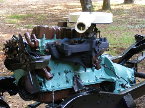 Engine assembly with turquoise block, brown valve covers, and air cleaner. Mounted on black frame pieces