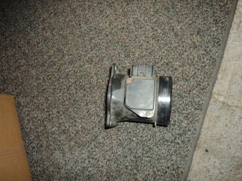 2004 Mercury Grand Marquis - A black mass air flow sensor is shown resting on a carpeted floor.