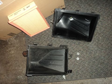 2004 Mercury Grand Marquis - Disassembled air filter housing and a new filter are laid out on a carpeted surface.