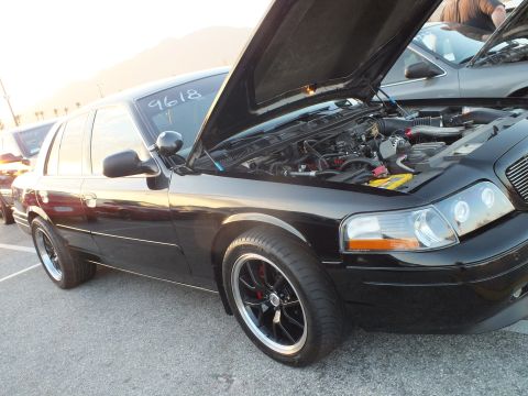 2003 Ford Crown Victoria - black Mercury sedan with its hood up exposes the engine bay, riding black wheels and marked 9618 on the glass.