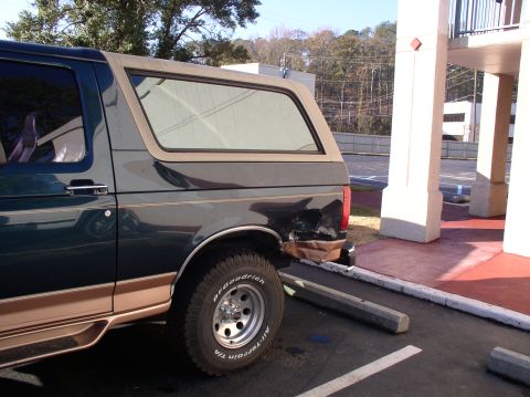 1995 Ford Bronco - This 1995 Ford Bronco shows damage to its rear quarter panel and has a removable tan top.