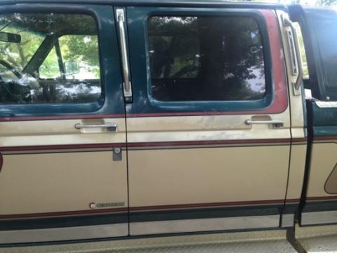1986 Ford Bronco - Side profile of a 1986 Ford Bronco showing its two-tone paint scheme and door handles.